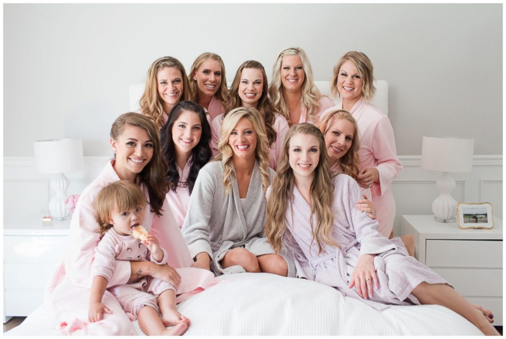 Bridesmaids in robes on a bed