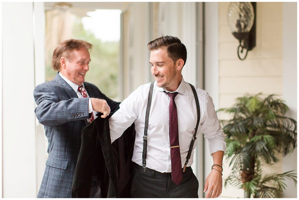 groom getting ready on the wedding day with dad's help