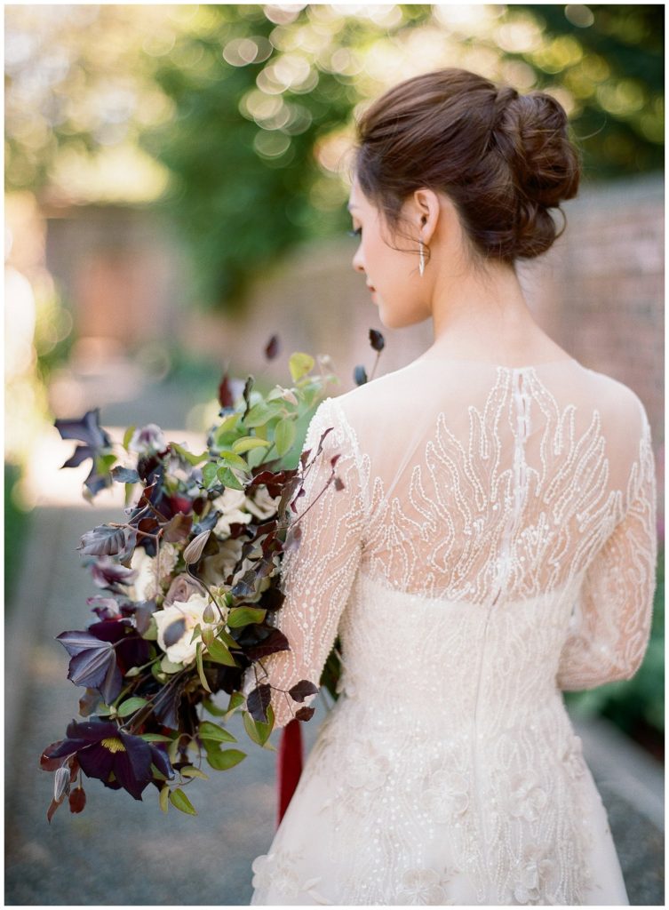 Illusion back wedding dress with purple bouquet by Thatch Floral || The Ganeys