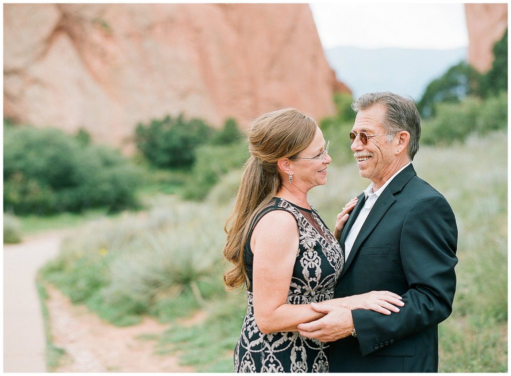 Couple in elegant black attire for engagement session at Garden of the Gods