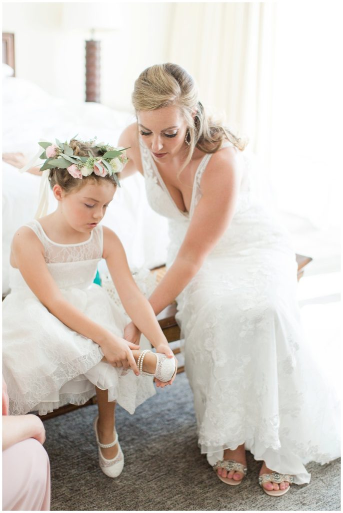 Bride helping flower girl with shoes at Lake Nona Country Club || The Ganeys