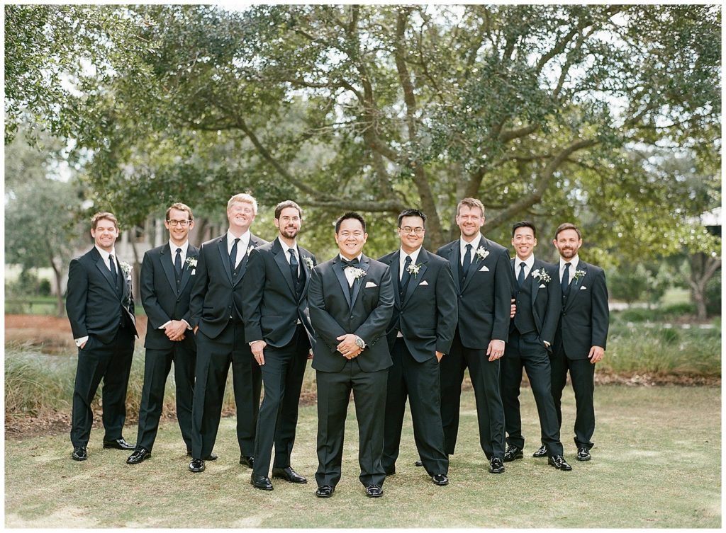 groomsmen in black suits from Men's warehouse