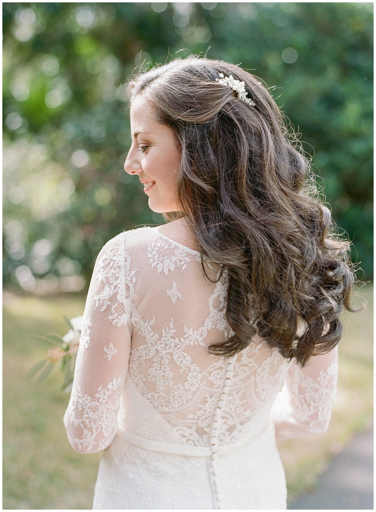 Bride in illusion back lace gown from Allure Bridals with loose curly hair || The Ganeys