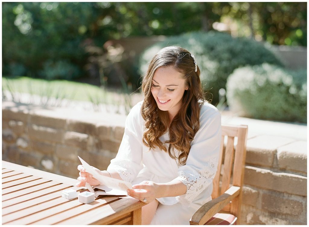 bride reading wedding note on the day of her wedding at Estancia La Jolla