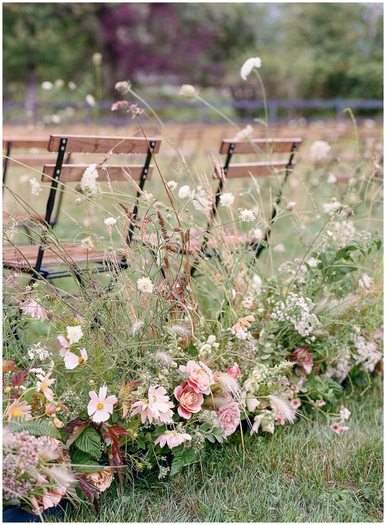 florals that appear to be growing directly into the ceremony seating by Gather Design Company