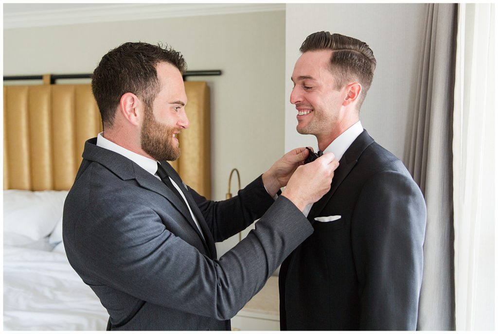 groom getting ready with help of groomsman
