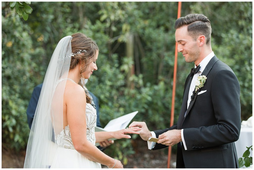 groom giving bride ring during ceremony