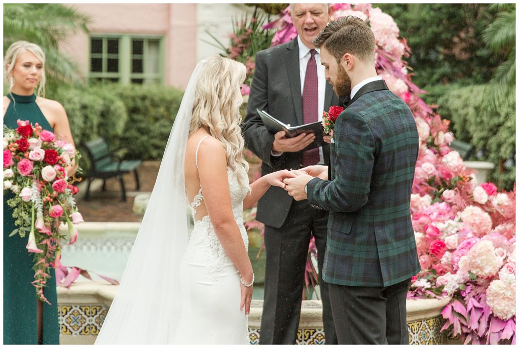 groom putting ring on bride at Vinoy Wedding Ceremony in Tea Garden