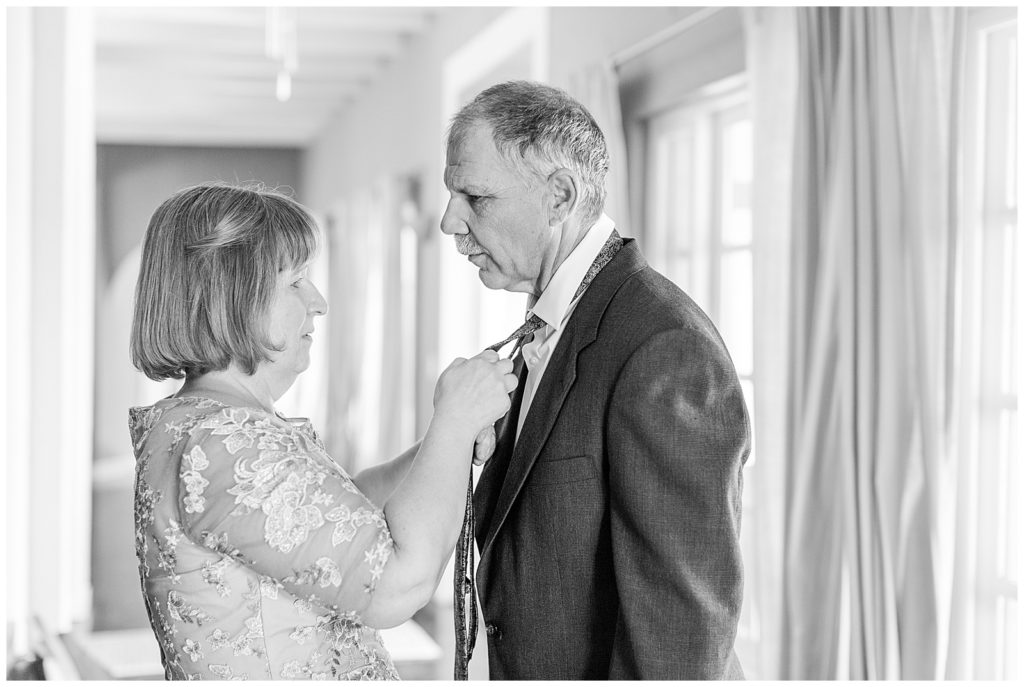 Mother of the bride helping her dad with tie