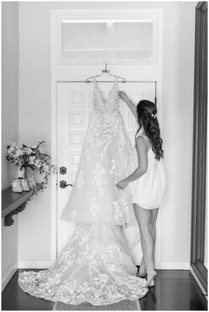 bride getting her Calla Blanche wedding dress down from hanger