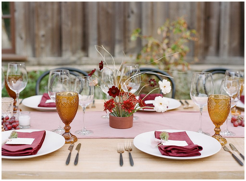 mauve velvet table runner with fruit and ikebana floral arrangement for fall wedding at Holman Ranch with Ruby and Rose