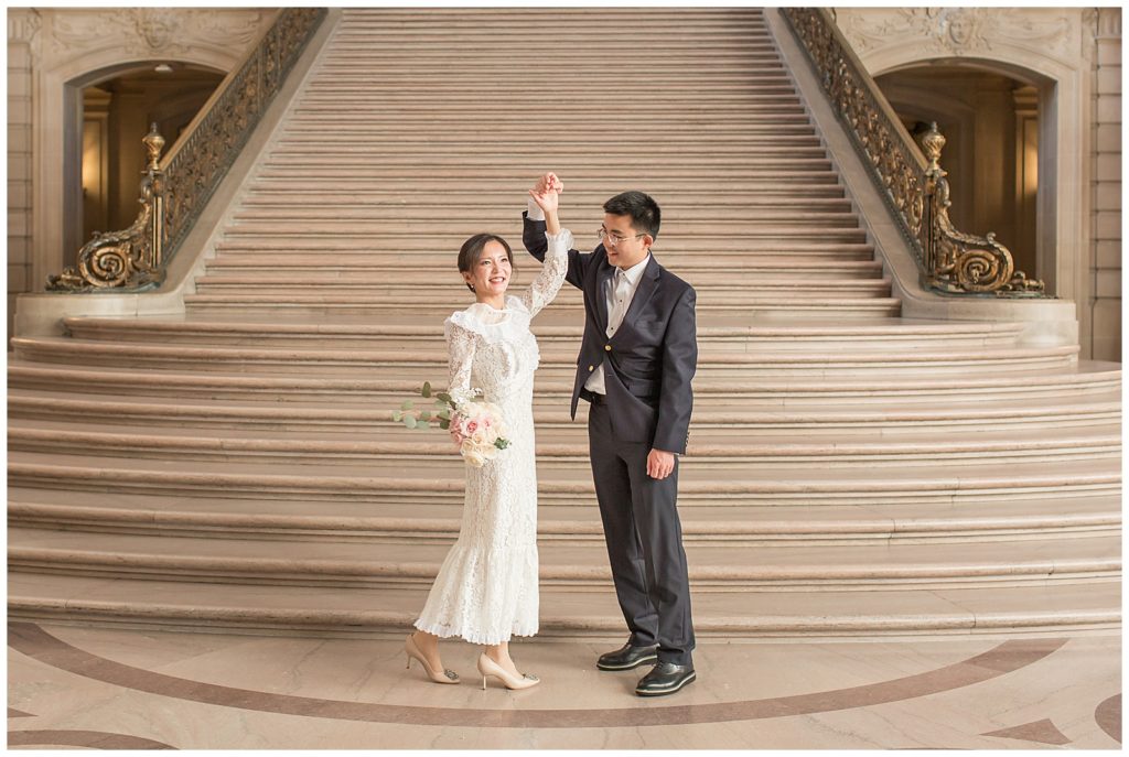 couple dancing in front of grand staircase at SF City hall