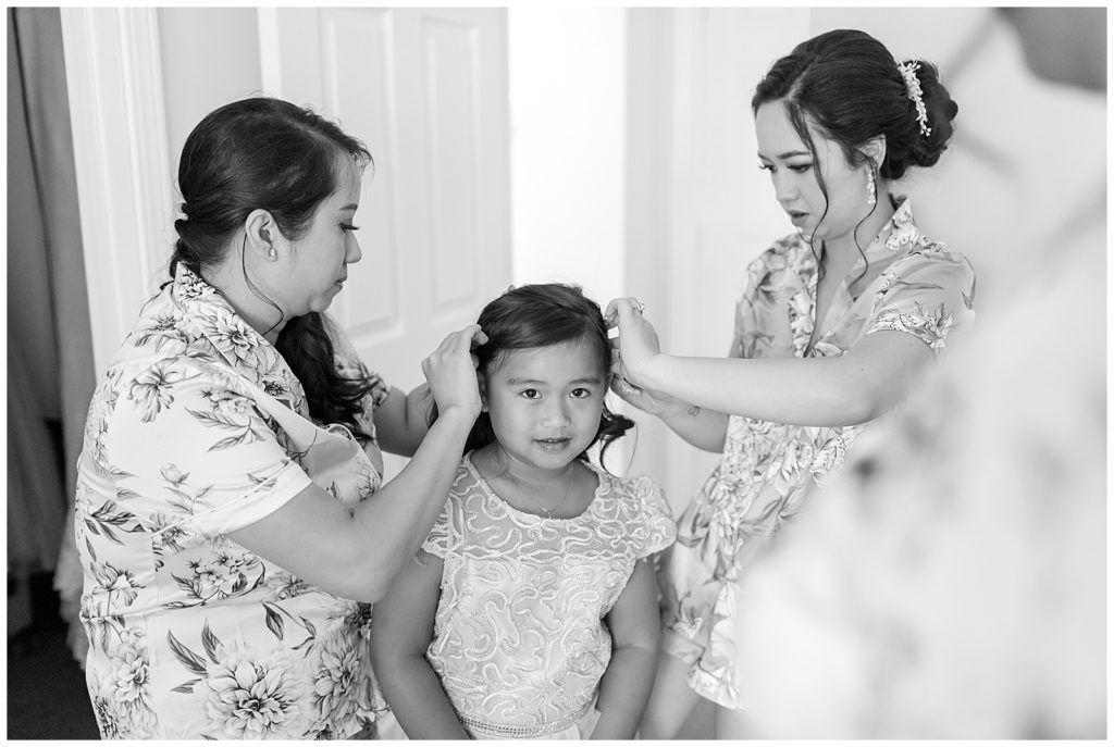 bride helping younger sister get ready for wedding