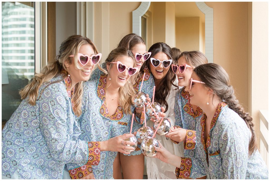 bride with bridesmaids heart glasses getting ready on wedding day
