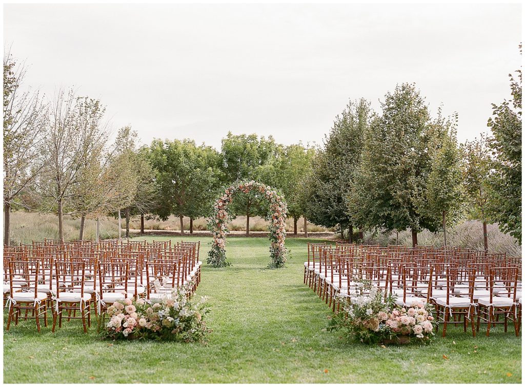 Floral arch with hues of orange and pink for Bear Flag Farm wedding 