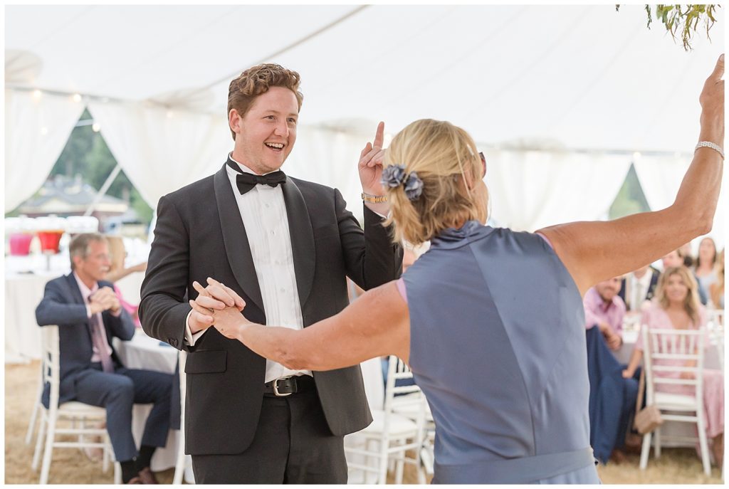 parent dances under floral chandelier in sailcloth tent wedding on Bainbridge Island