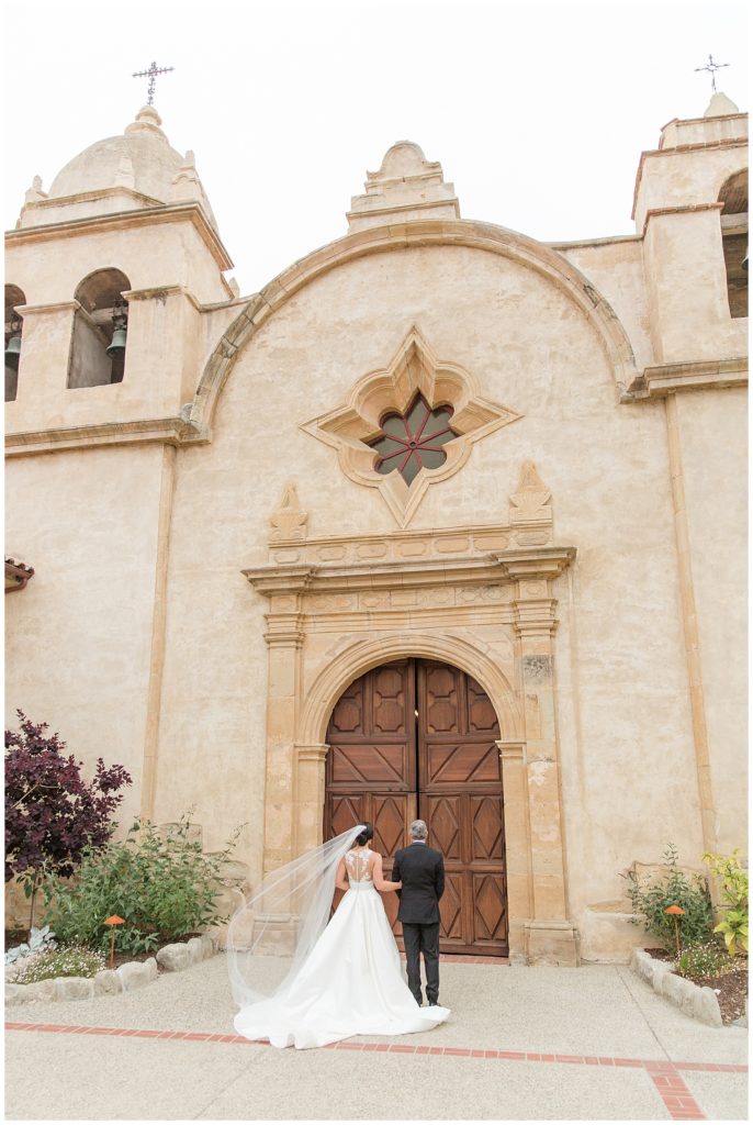 Bride and dad waiting outside of Carmel Mission Basilica before wedding ceremony