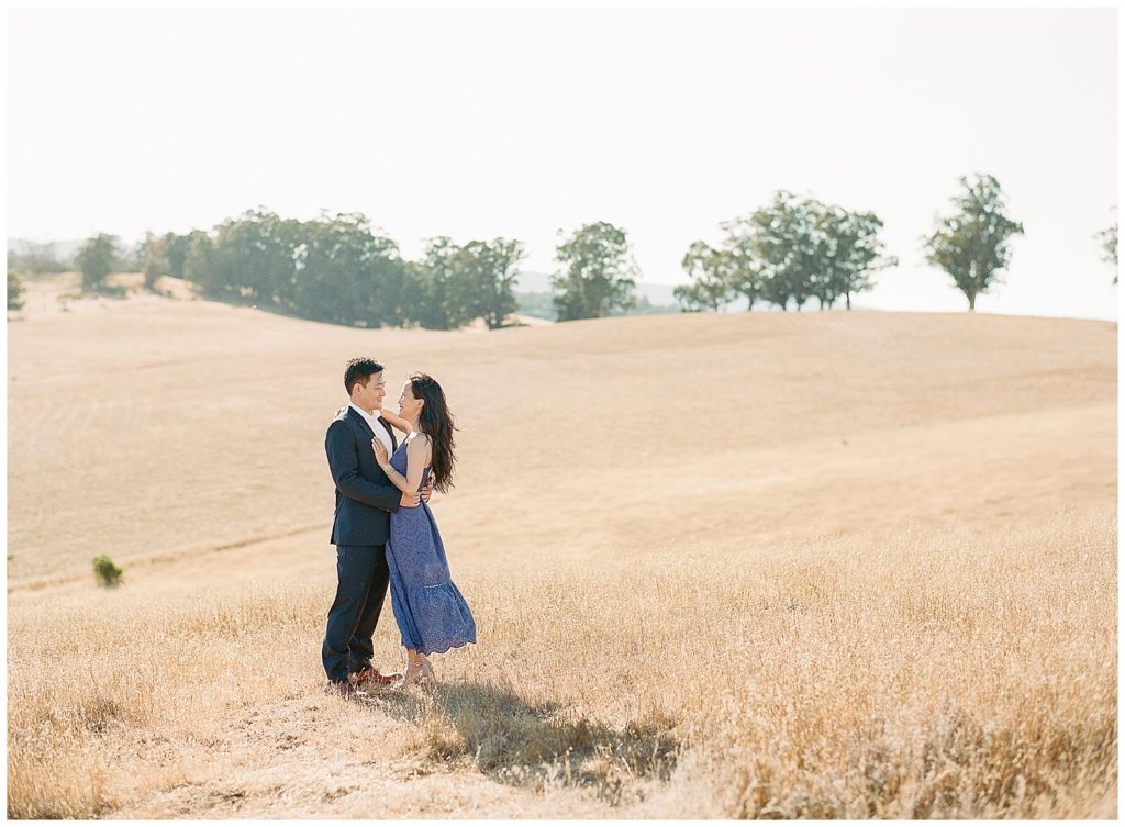 Golden California hills engagement photos with blue eyelet dress
