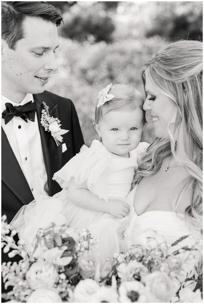 portrait of couple with their baby on wedding day