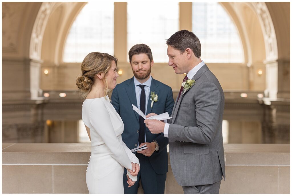 exchanging vows during SF City hall 4th floor balcony wedding 